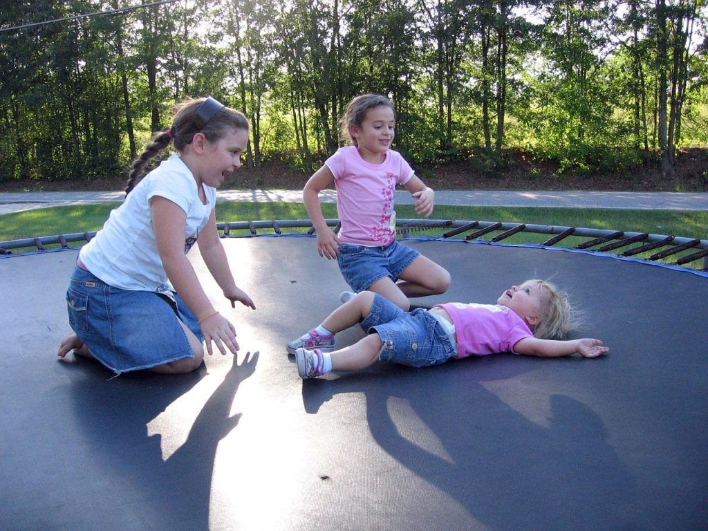 Familie springt op een veilige trampoline in de tuin, genietend van buiten spelen en gezamenlijke activiteiten