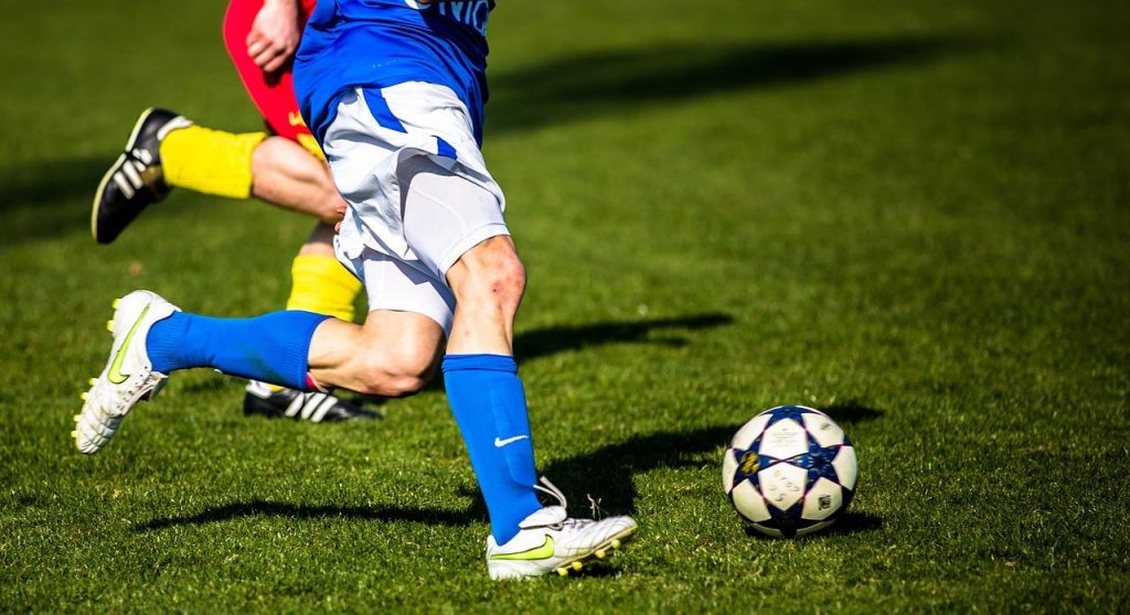 Kinderen spelen voetbal samen, illustrerend het belang van voetbal in de samenleving voor gemeenschapsvorming en gezondheid