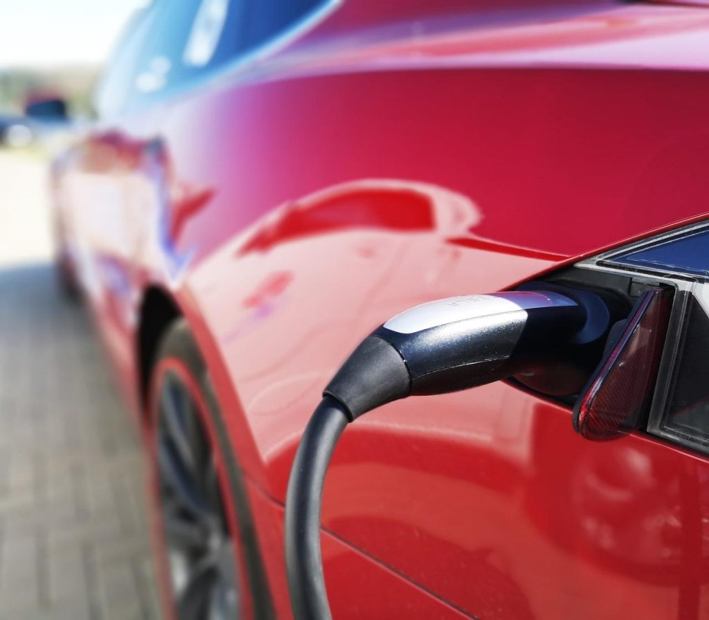 Elektrische auto laadt op bij openbare laadstations in stedelijke omgeving, symbool voor duurzame stadsinfrastructuur